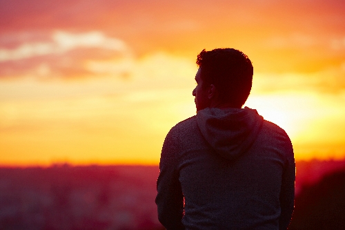 Image of a man in front of a sunset
